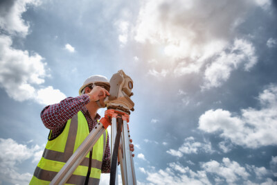 Surveyor’s telescope at construction site or Surveying for making contour plans are a graphical representation of the lay of the land before startup construction work